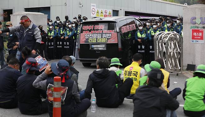 20일 경남 진주시 정촌면 CU 진주물류센터 앞에서 경찰이 민주노총 화물연대 CU지회 노조원들을 막아 서고 있다. 물류센터 정문 앞에는 진입을 시도하던 노조 차량이 보이고 있다. 이날 현장에서는 화물차와 집회 참가자 3명이 충돌해 1명이 숨지고 2명이 다치는 사고가 발생했다. /뉴스1