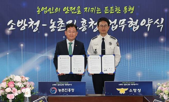 이승돈 농촌진흥청장(왼쪽)과 김승룡 소방청장이 지난 20일 세종시 정부세종청사 소방청 중회의실에서 열린 '농업 현장 안전체계 강화를 위한 업무협약식'에서 기념촬영을 하고 있다. 농촌진흥청 제공