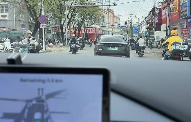 지난 17일 베이징 마쥐차오에 있는 차량과 전동차, 자전거가 섞인 거리를 중국 자율주행 기술기업 포니에이아이(AI)의 무인택시가 달리고 있다. 베이징/이정연 특파원