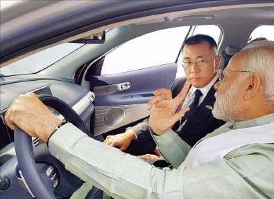 <정의선-모디 8년 전 약속> 정의선 현대자동차그룹 회장(왼쪽)이 2018년 ‘한·인도 비즈니스 포럼’에서 수소전기차 넥쏘에 동석한 나렌드라 모디 인도 총리와 대화하고 있다. 오른쪽 사진은 현대차와 TVS모터컴퍼니가 공동 개발할 예정인 삼륜차 모델.   현대차·주한인도대사관 제공