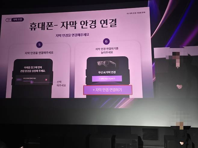 지난 20일 롯데시네마 도곡에서 진행된 청각장애인을 위한 ‘배리어프리 특별 상영회’. 스크린에 기기와 안경을 연결하는 방법이 소개되고 있다. 손미정 기자