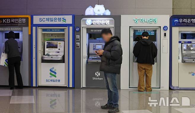 [서울=뉴시스] 조성우 기자 = 12일 서울 시내의 한 건물에서 시민들이 시중은행 ATM기기를 이용하고 있다.KB·신한·하나·우리·NH농협 등 5대 금융그룹은 지난해 당기순이익 20조 4700억 원을 기록하며 사상 처음으로 '20조 원 시대'를 열었다. 이는 전년(18조 8742억 원) 대비 1조 5958억 원(8.45%) 증가한 규모다. 2026.02.12. xconfind@newsis.com