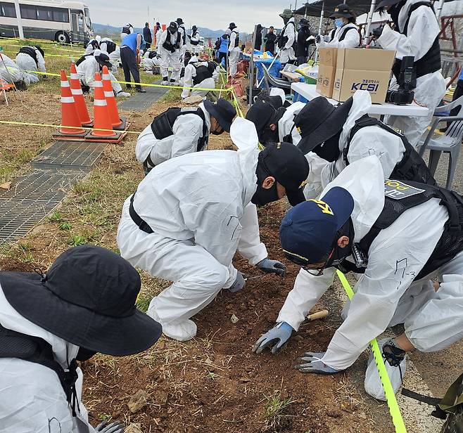 지난 20일 무안국제공항 내 둔덕 주변에서 경찰 과학수사대 인원들이 유해를 발굴하고 있다. <12·29무안공항제주항공여객기참사유가족협의회 제공>