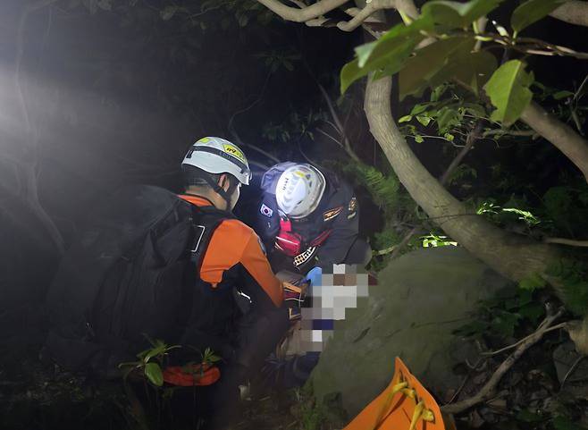 열화상 드론과 비번 근무자까지 총동원된 끈질긴 민관 합동 수색 끝에, 지난 21일 밤 울릉소방서 구조대원들이 내수전 산속 고립 지역에서 실종자를 발견해 응급처치하고 있다. /울릉119안전센터 제공