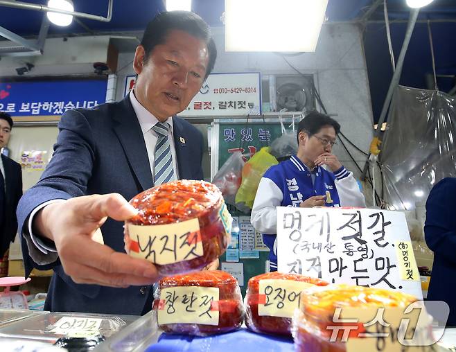정청래 더불어민주당 대표가 22일 경남 통영 통영중앙전통시장을 찾아 낙지젓을 들어 보이고 있다. 2026.4.22 ⓒ 뉴스1 윤일지 기자