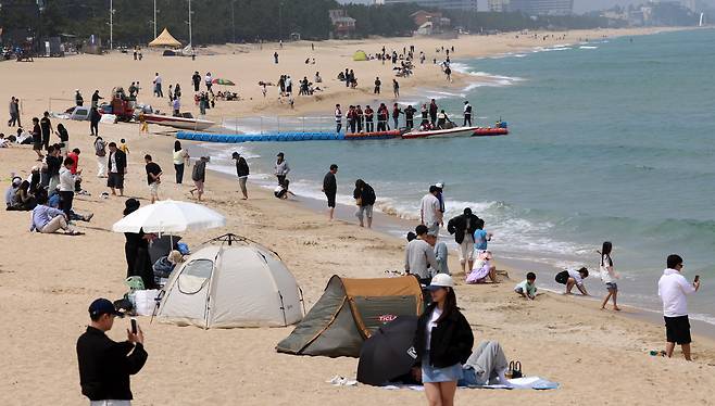 19일 강원 강릉시 안목해변에서 관광객들이 텐트와 파라솔을 치고 시원한 바닷바람을 맞으며 앞당겨 찾아온 더위를 식히고 있다. /연합뉴스