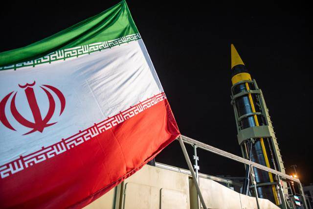 21일 이란 테헤란 엥겔랍 광장에 게양된 이란 국기 뒤편으로 이란군이 운용하는 코람샤흐르-4 미사일이 전시돼 있다. 테헤란=UPI 연합뉴스