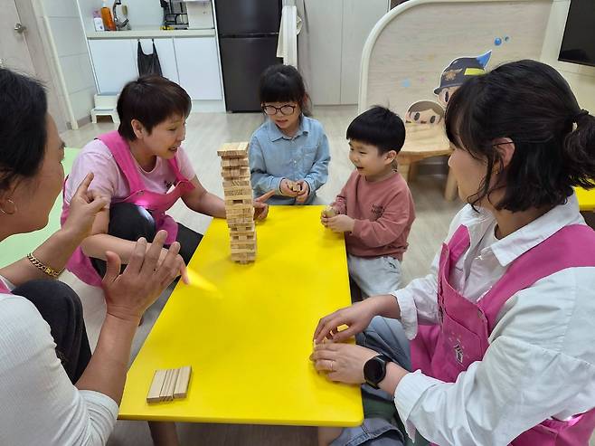 지난 21일 경북 고령군 고령소방서 내 '119아이행복돌봄터'에서 돌보미들과 함께 아이들이 보드게임을 하고 있다. 김정석 기자