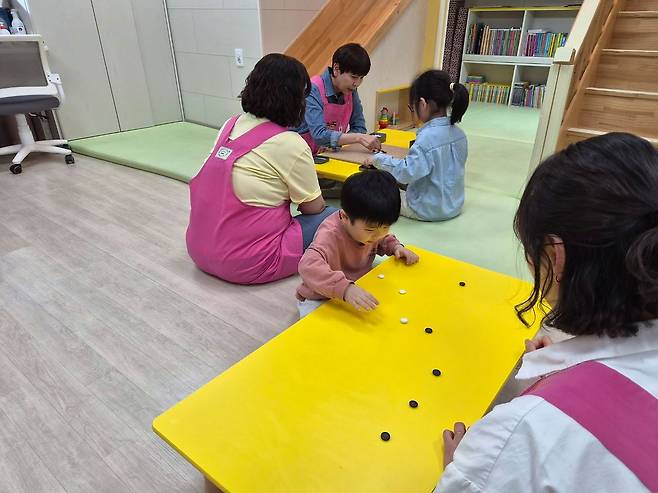 지난 21일 경북 고령군 고령소방서 내 119아이행복돌봄터에서 돌보미들과 아이들이 바둑돌을 이용한 게임을 하고 있다. 김정석 기자