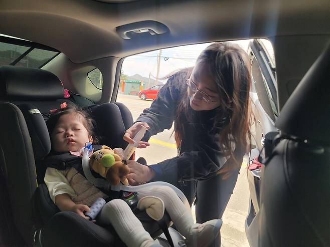 ▲ 지난달 12일 원주세브란스기독병원 이동 중 남경아 씨가 홍천 부근 국도변에 차를 세우고 딸 시은이의 밥을 먹이고 있다. 선천성 심장병 등으로 중증 수술 여러 개를 마친 아이는 위루관을 통해 영양을 공급받는다