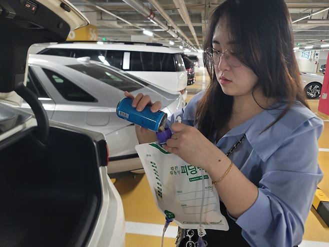 ▲지난 2일 삼성서울병원 주차장에서 남경아 씨가 딸 시은이 피딩(위루관을 통해 영양을 주입하는 행위)을 위해 피딩백을 채우고 있다. 이설화 기자