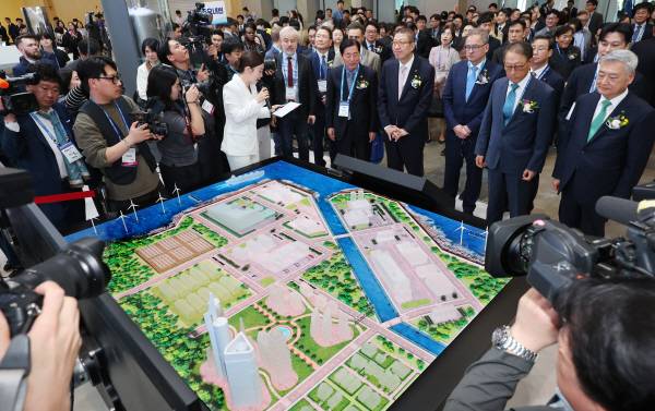 22일 부산 해운대구 벡스코 제1전시장에서 개막한 ‘2026 부산국제원자력산업전’에서 관람객들이 원자력 스마트시티를 살펴보고 있다.     24일까지 열리는 이번 행사에는 19개국의 전력, 원자력 관련 기업 130곳이 참가해 소형모듈원자로(SMR) 등 세계 원전 시장의 최신 기술을 소개하며, 한국원자력연차대회와 제25차 태평양연안국 원자력회의가 동시에 개최된다. 연합뉴스