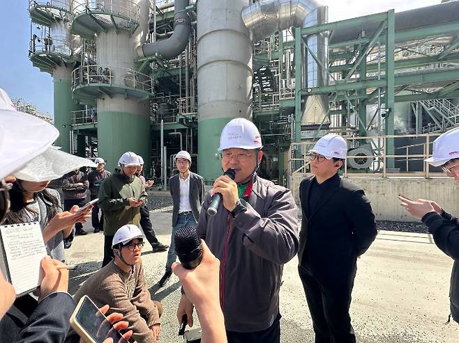 금호석유화학 이용선 여수에너지 발전기술팀장이 21일 CCUS 설비 현장에서 공정을 설명하는 모습. 뒤로 보이는 설비가 오른쪽부터 순서대로 냉각기, 흡수탑, 탈거탑이다. 금호석유화학 제공