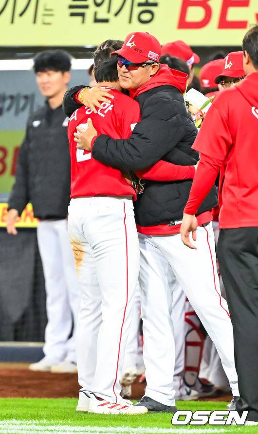 [OSEN=대구, 민경훈 기자] 21일 오후 대구삼성라이온즈파크 ‘2026 신한 SOL Bank KBO리그' 삼성 라이온즈와 SSG 랜더스와 경기가 열렸다.이 경기에서 SSG은 연장 10회 박성한의 결승타에 힘입어 5-4로 이겼다. 박성한은 1회 첫 타석에서 안타를 추가하며 개막 후 19경기 연속 안타를 때려내며 44년 만에 이 부문 신기록을 세웠고 결승타의 주인공이 됐다.경기를 마치고 SSG 박성한이 이숭용 감독에게 신기록 축하 꽃다발을 받고 포옹을 하고 있다. 2026.04.21 / rumi@osen.co.kr