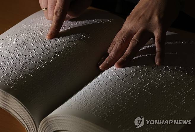 세상과의 연결통로 점자 (수원=연합뉴스) 홍기원 기자 = '한글 점자의 날'을 하루 앞둔 3일 경기도 수원시 영통구 수원시장애인종합복지관 사랑샘도서관에서 관계자가 점자책을 보여주고 있다. 2025.11.3 xanadu@yna.co.kr