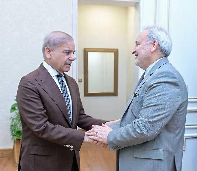 샤리프 파키스탄 총리, 주파키스탄 이란대사 접견 셰바즈 샤리프 파키스탄 총리(왼쪽)가 22일(현지시간) 레자 아미리 모가담 주파키스탄 이란대사와 만나 악수하고 있다. [샤리프 파키스탄 총리 X 캡처. 재판매 및 DB 금지]