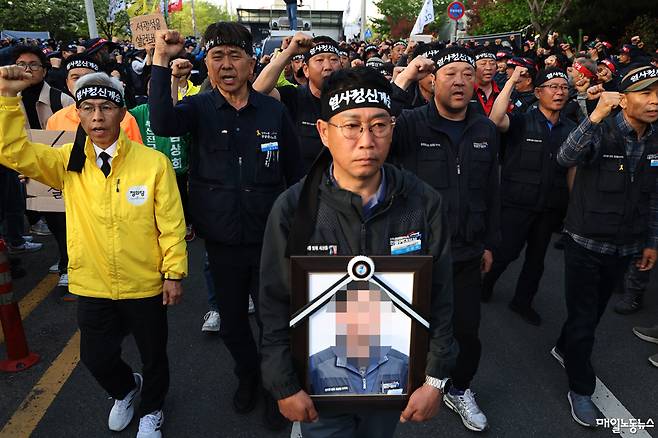 ▲ 김동국 화물연대본부 본부장과 집회 참가자들이 21일 고인의 영정을 들고 사고 현장으로 걸어가고 있다. <정기훈 기자>