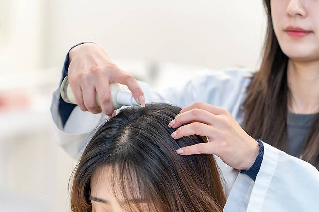 한국콜마 헤어연구팀 연구원이 스칼프 선에센스를 두피에 바르는 테스트를 진행하고 있다. / 한국콜마