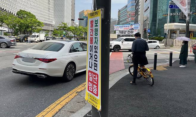 23일 대전 서구 은하수네거리에 우회전 일시정지 현수막이 설치된 가운데 한 차량이 우회전 방향으로 진행하고 있다. 우수아 기자