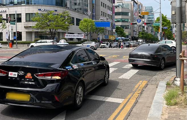 23일 시교육청네거리에서 전방 신호가 적신호임에도 차량들이 일시정지 하지 않고 연달아 통과하고 있다. 우수아 기자