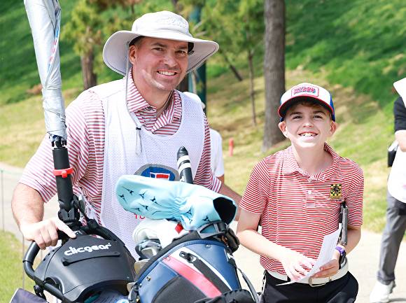 23일 경기 안산시 대부도 더헤븐리조트 내 더헤븐CC에서 열린 ‘2026 U.S. Kids Golf Korean Championship(유에스 키즈 골프 코리안 챔피언십)’ 2라운드에 출전한 미국 웨인 쿤스 선수와 캐디가 카메라를 향해 웃음을 짓고 있다.  [사진=더헤븐리조트 제공]