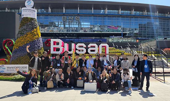 재학 당시 한양사이버대학교 디자인대학원 교수, 원우들과 함께 부산역 앞에서 환한 미소로 단체 사진을 찍고 있는 김태영 동문(뒷줄 왼쪽에서 첫번째). 나이와 직업을 불문하고 끈끈한 네트워크를 형성할 수 있는 것은 한양사이버대학교만의 또 다른 장점이다.