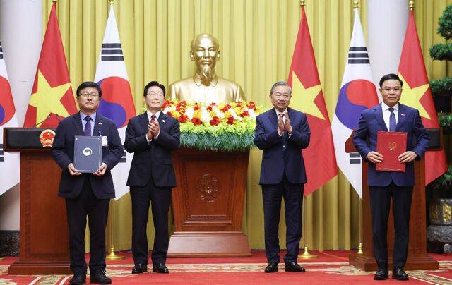 이재명 대통령과 또럼 베트남 공산당 서기장 겸 국가주석이 22일 하노이 주석궁에서 전력 인프라 협력 양해각서(MOU) 체결식을 하고 있다. 김성환 기후에너지환경부 장관(맨 왼쪽)과 레 마잉 훙 베트남 산업무역부 장관이 양해각서를 들어 보이고 있다. 연합뉴스