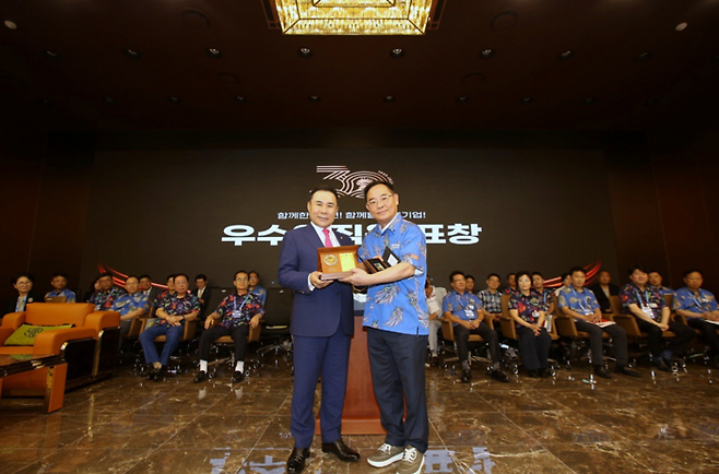 주상집 BBQ 세계식문화과학기술원 사장(오른쪽)이 윤홍근 BBQ 회장에게서 우수직원 표창을 받은 뒤 기념촬영을 하고 있다. 제너시스BBQ 그룹