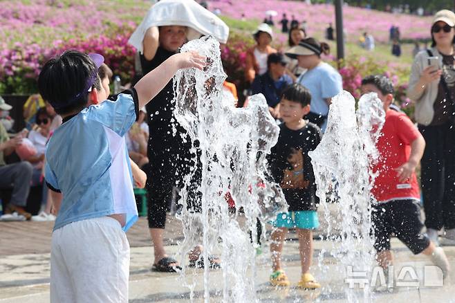 [서울=뉴시스] 권창회 기자 = 서울 낮기온이 29도까지 오르는 등 초여름 더위가 이어지는 19일 서울 노원구 불암산 나비정원에서 열린 2026 불암산 철쭉제를 찾은 아이들이 물놀이를 하고 있다. 2026.04.19. kch0523@newsis.com