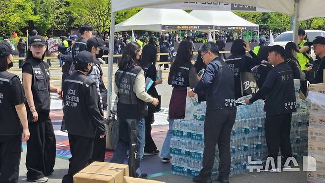 [평택=뉴시스] 노조 관계자들이 결의대회에 참석한 조합원들에게 물품을 나눠주고 있다. 2026.04.23. newswith01@newsis.com