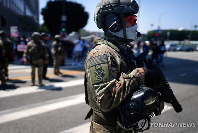 얼굴을 가린 ICE 요원 [AP=연합뉴스. 재판매 및 DB 금지]