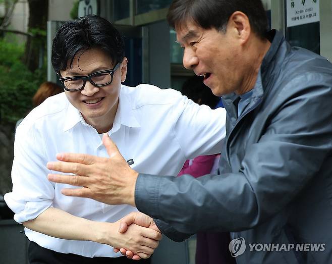 한동훈 "만덕 주민입니다" (부산=연합뉴스) 손형주 기자 = 한동훈 전 국민의힘 대표가 14일 오후 부산 북구 만덕2동 행정복지센터를 찾아 전입신고를 마친 뒤 주민들과 사진을 찍고 있다. 한 전 대표는 이곳으로 전입신고를 하며 전재수 의원의 부산시장 출마로 보궐선거 진행될 예정인 부산 북구갑 출마를 공식화했다. 2026.4.14 handbrother@yna.co.kr