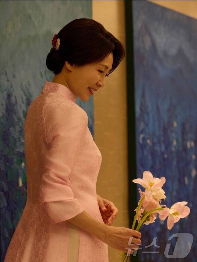 또 럼 베트남 공산당 서기장 부인 응오 프엉 리 여사가 선물한 분홍색 아오자이를 입고 있는 김혜경 여사.(이재명 대통령 인스타그램 갈무리) ⓒ 뉴스1 한재준 기자