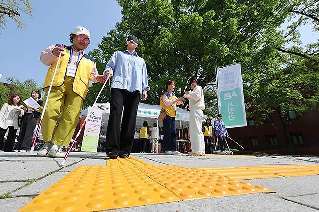 24일 서울 종로구 마로니에 공원에서 열린 종로구 어울누림 축제에서 한 시민이 안대를 쓰고 시각장애인 점자 블록을 체험하고 있다. 2025.4.24 (ⓒ뉴스1, 무단 전재-재배포 금지)