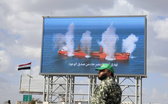 지난해 9월 예멘 사나에서 후티 반군 군인이 지난 2023년 홍해에서 후티 반군의 공격을 받아 침몰하는 라이베리아 국적 선박의 모습을 담은 디지털 광고판 앞에 서 있다. EPA=연합뉴스