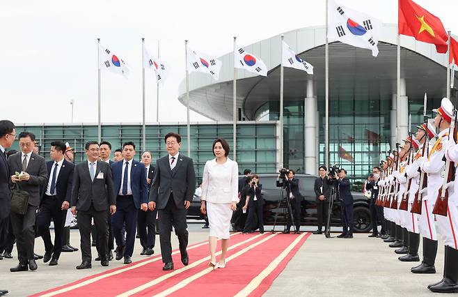 인도·베트남 국빈 방문 일정을 마치고 귀국하는 이재명 대통령과 김혜경 여사가 24일(현지시간) 베트남 하노이 노이바이 국제공항에서 공군 1호기로 이동하고 있다. [연합]