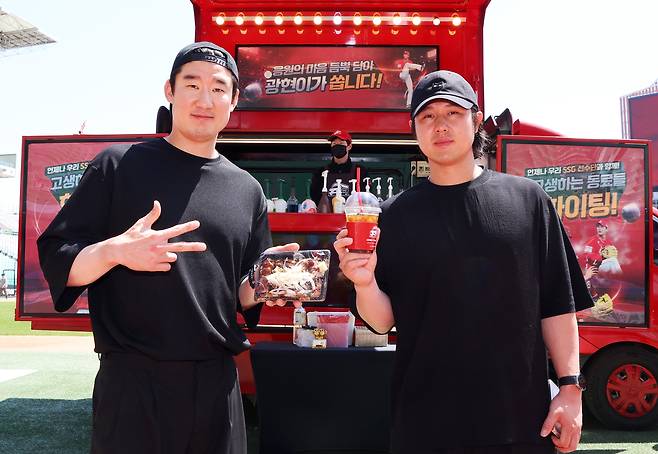 SSG 오태곤(왼쪽)과 최정이 24일 김광현이 선물한 커피차와 푸드트럭 앞에서 사진을 촬영하고 있다. SSG랜더스 제공