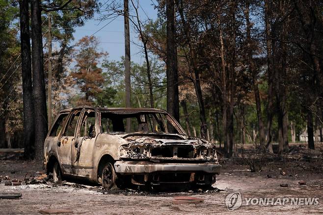 미국 조지아주 산불 확산…주지사 비상사태 발령 (앳킨슨=AFP·연합뉴스) 23일(현지시간) 산불이 발생한 미국 조지아주 앳킨슨에 전소된 차량이 방치돼 있다. [AFP 연합뉴스]