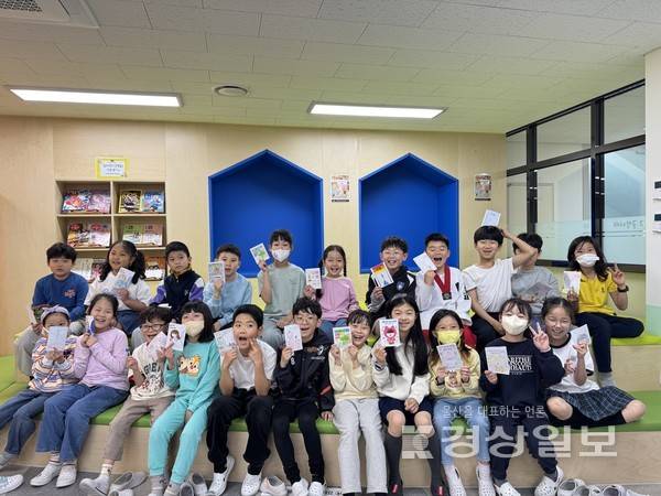 복산초 학생들이 지난 23일 도서관에서 '나만의 책표지 꾸미기' 활동을 하고 기념사진을 찍고 있다. 울산시교육청 제공