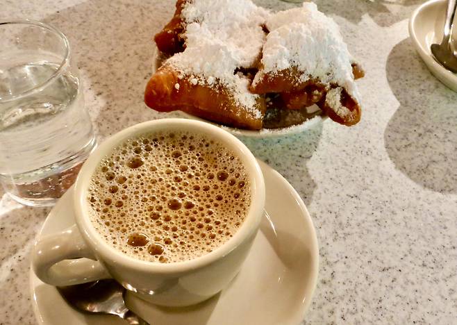 ‘카페 뒤 몽드(Café du Monde)’의 베녜(Beignet). 가운데 구멍이 없는 사각형의 프랑스식 도넛으로 프랑스인들은 “눈 덮인 알프스 못지않게 나를 흥분시키는 풍경이다”라고 표현한다. /박진배 뉴욕 FIT 교수·마이애미대학교 명예석좌교수