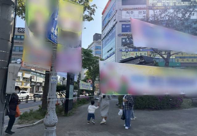 포천 소흘읍 송우리 중앙사거리 횡단보도 인근에 낮게 설치된 불법 현수막이 보행자 안전을 위협하고 있다. 손지영 기자