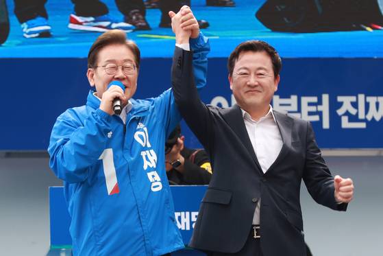이재명 더불어민주당 대선 후보가 17일 오후 광주 서구 김대중컨벤션센터 광장에서 열린 선거유세에서 지지를 선언한 김용남 전 국민의힘 의원의 손을 잡고 있다. 김성룡 기자.