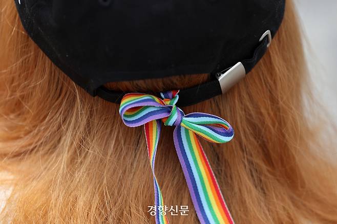 10개 대학의 단체들로 이뤄진 서울퀴어퍼레이드 서울광장 사용 불허 규탄 대학가 무지개 행진 기획단이 2023년 5월12일 서울 서대문구 스타광장에서 가진 기자회견 중 한 시민이 퀴어의 상징인 무지개 리본을 모자에 묶은 채 함께하고 있다. 경향신문 자료사진