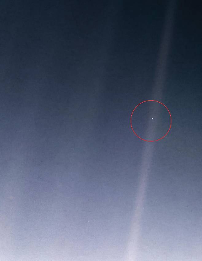 보이저 1호가 1990년 2월14일 촬영한 지구의 모습이 빨간색 원 내부에 아주 작은 점으로 확인된다. 이 미미한 흔적은 지금까지도 ‘창백한 푸른 점’으로 불리고 있다.  NASA 제공