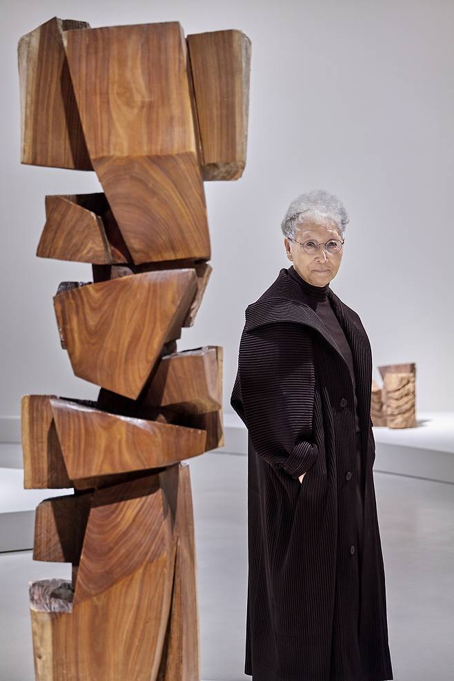 자신의 나무조각 옆에서 포즈를 취한 김윤신 작가.&nbsp;호암미술관 제공