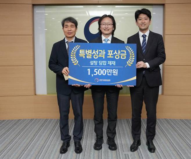 지난 22일 공정거래위원회에서 열린 제1회 특별성과 포상금 수여식에서 주병기 공정위원장(가운데)이 정문홍 사무관(왼쪽)과 우병훈 서기관과 함께 기념사진을 찍으며 환하게 웃고 있다. 공정위 제공