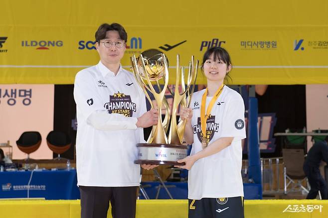 KB스타즈 김완수 감독(왼쪽)과 허예은이 26일 용인체육관서 열린 삼성생명과 챔피언 결정전 3차전서 80-65로 승리해 통합우승을 확정한 뒤 트로피를 들고 기념촬영을 하고 있다. 사진제공｜WKBL