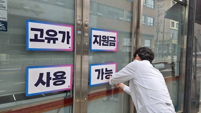 고유가 부담 완화를 위한 정부 지원금 지급이 본격화되면서 유통업계의 희비가 뚜렷하게 엇갈리고 있다. 사용처 제한에 따라 소비가 근린 상권으로 집중되면서 편의점은 '직접 수혜'를 기대하는 반면, 대형마트와 이커머스는 '간접 효과'에 기대는 구조가 형성되고 있다. 사진은 27일 오후 광주 북구 한 편의점주가 편의점 창문에 '고유가 지원금 사용 가능' 안내문을 부착하고 있는 모습. /박준호 기자 bjh@namdonews.com