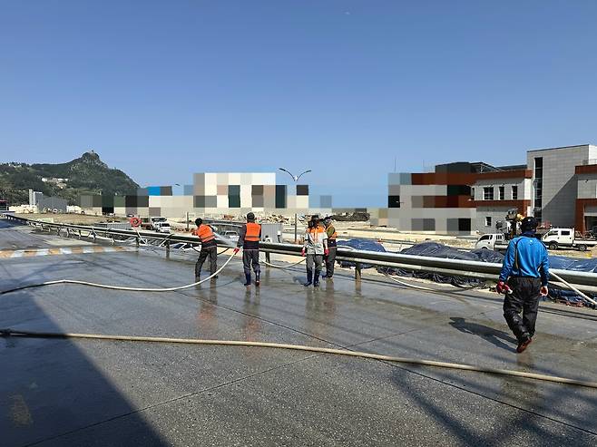 울릉 사동 의용소방대원들이 고압 소방 호스를 어깨에 메고 일주도로를 씻어내고 있다. /사동 의용소방대 제공