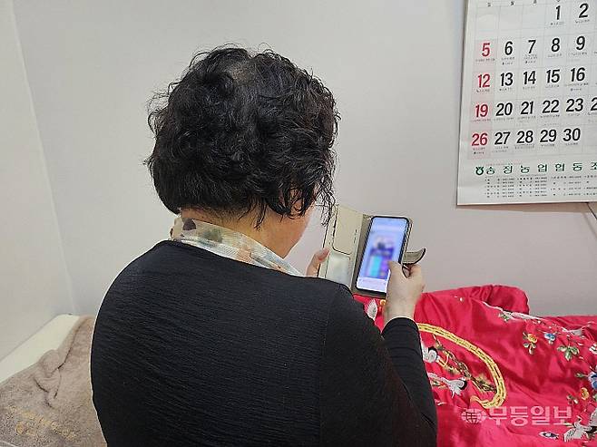 광주 북구에 사는 민주당 권리당원 이경숙(68·여·가명)씨가 핸드폰으로 전남광주통합특별시장 경선 관련 홍보물을 보고 있다.